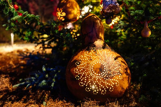a large gourd with a pattern of holes in it and lit up from within